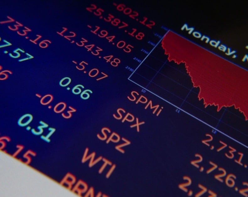 Stock market dashboard with red downward chart and green/red numbers showing indices and values (SPX, SPY, SPZ, WTI).