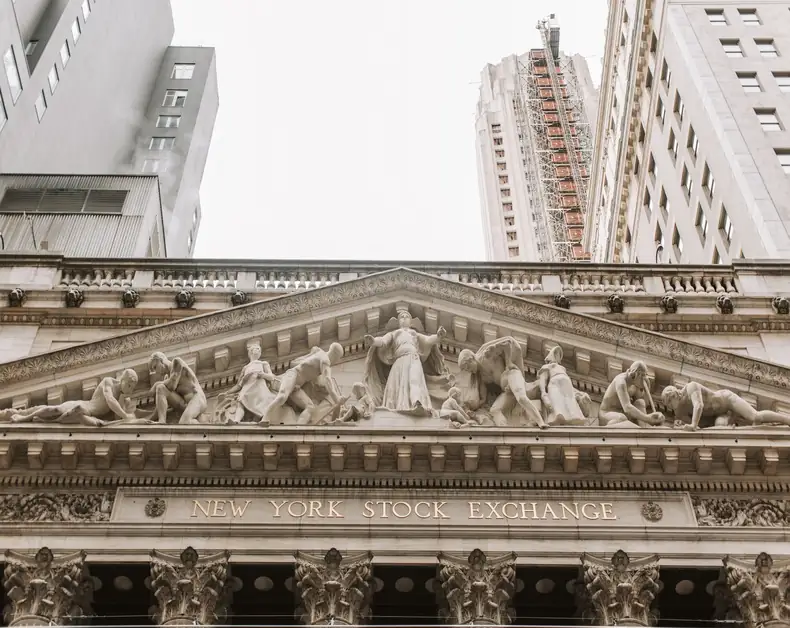 Facade of the New York Stock Exchange with classical sculptures above the entrance.